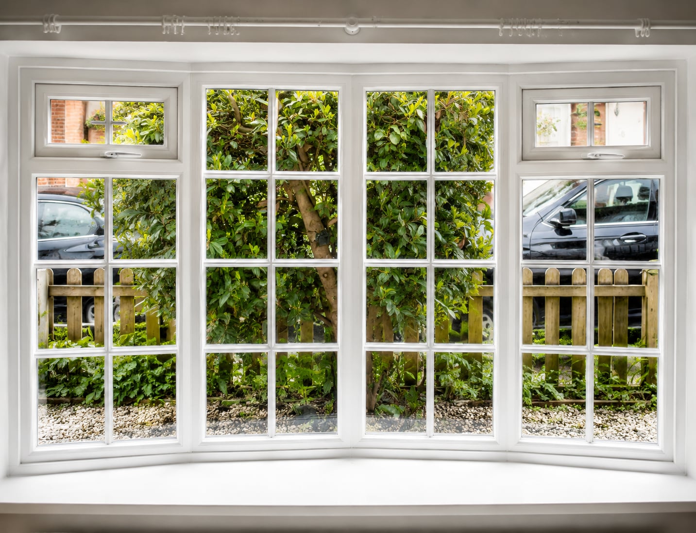 White timber bay casement window with glazing bars and top opening vents, seen from inside
