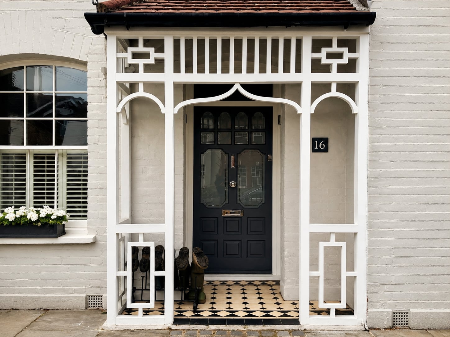 Dark navy timber door with glazed panels beneath an ornate white timber porch